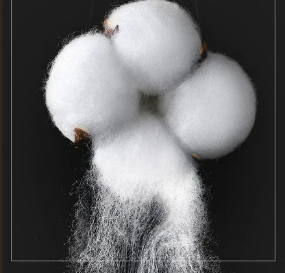 Plush white cotton boll with fluffy fibers and brown stem representing cream and lavender egyptian cotton hotel bedding set