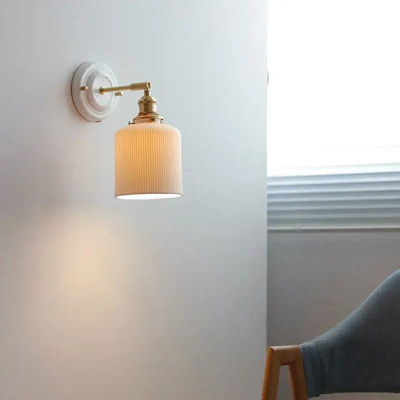 Cream ceramic LED wall light with copper arm featuring a cream ribbed glass lampshade and white ceramic mount by decorbites ceramic LED