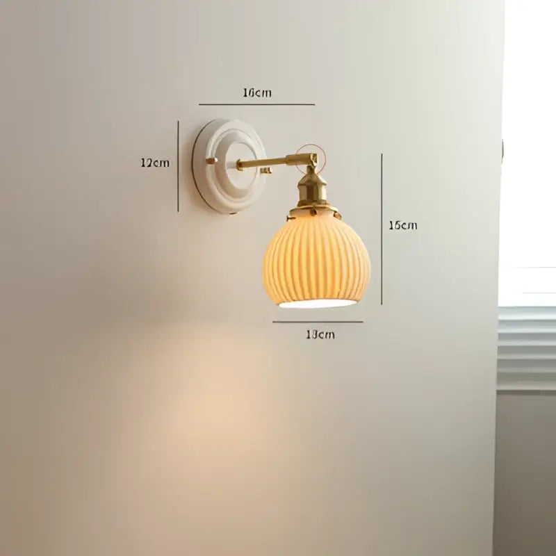 Cream ceramic led wall light with copper arm featuring a cream ribbed glass lamp and brass-finished metal mounting plate decorbites ceramic led