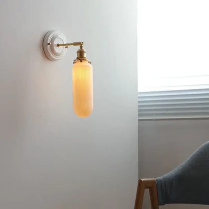 Cream ceramic led wall light with copper arm and warm amber ribbed glass shade for bedroom decorbites ceramic led
