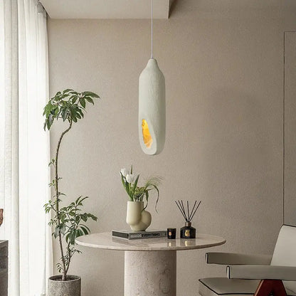 A cream ceramic pendant light with warm amber glow from decorbites cement handmade for living room decor