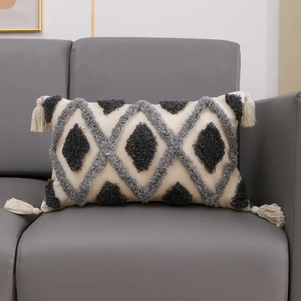 Cream-colored cushion cover with decorbites grey geometric tufted pattern and tassels for living room decor