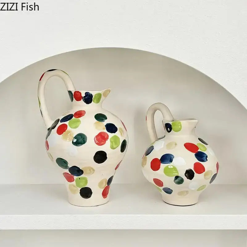 Two cream colorful dot ceramic pitchers with red green blue and black polka dots for kitchen floral decor by decorbites