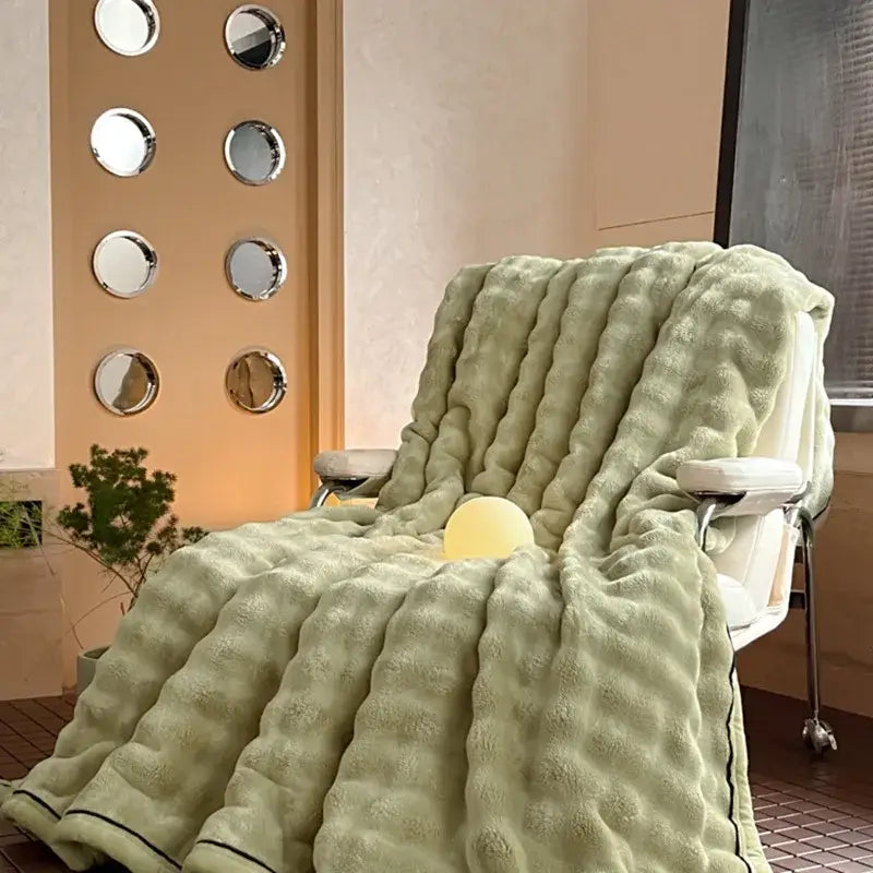 Cream cozy bubble faux rabbit fur blanket with light green ribbed throw and black trim for decorbites cozy bubble use