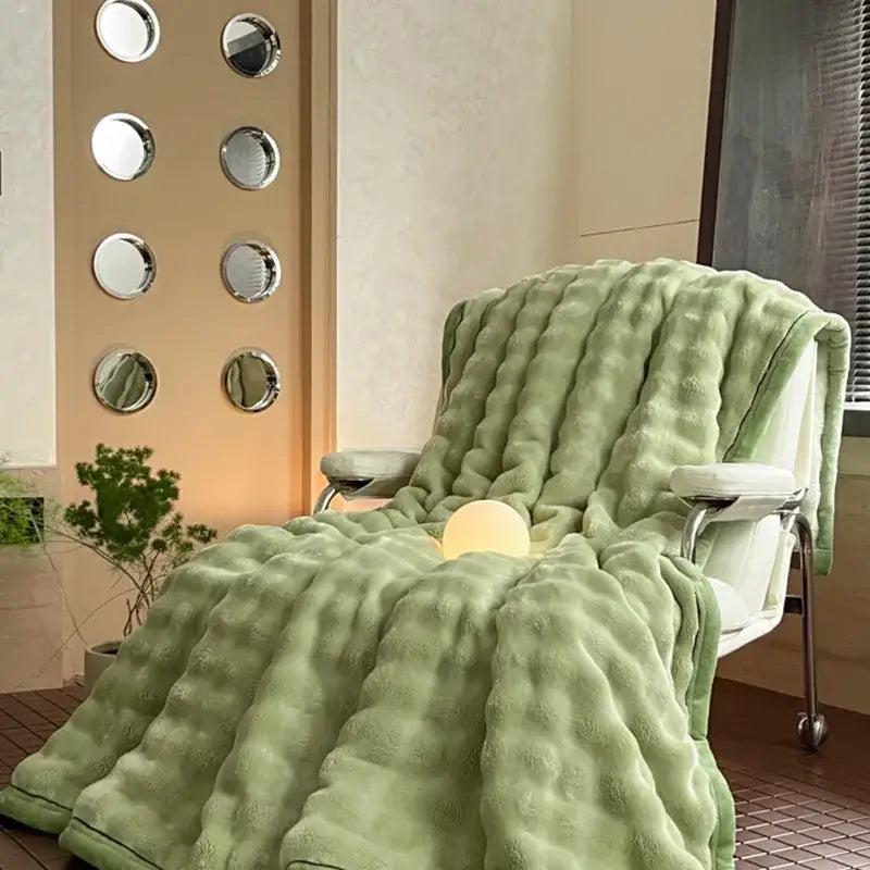 Cream cozy bubble faux rabbit fur bedroom throw in light green with textured quilted pattern draped on modern chair