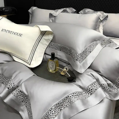 Silver satin pillowcases with intricate lace trim and embroidered lovehouse branding in cream eucalyptus lyocell 1000tc bedding set