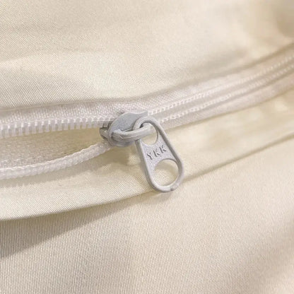 A silver-toned ykk zipper pull on white fabric in cream floral decorbites flowers embroidery silky duvet set