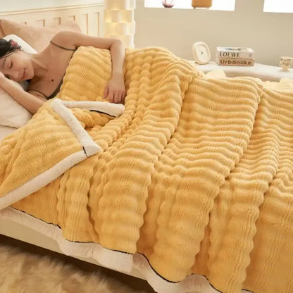 A cozy mustard-yellow fleece blanket with plush white sherpa lining and ribbed texture decorbites fluffy rabbit plush