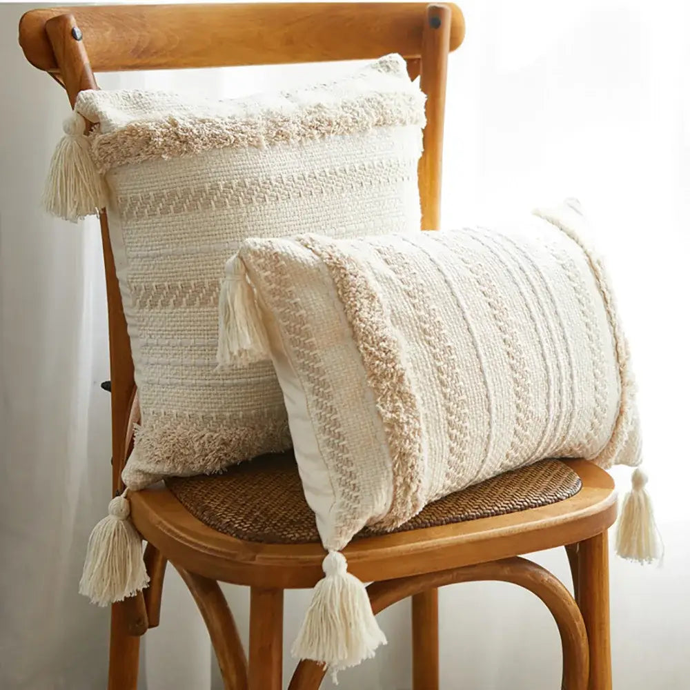 Two cream-colored textured knit throw pillows with tassels featuring decorbites geometric embroidery cushion cover design