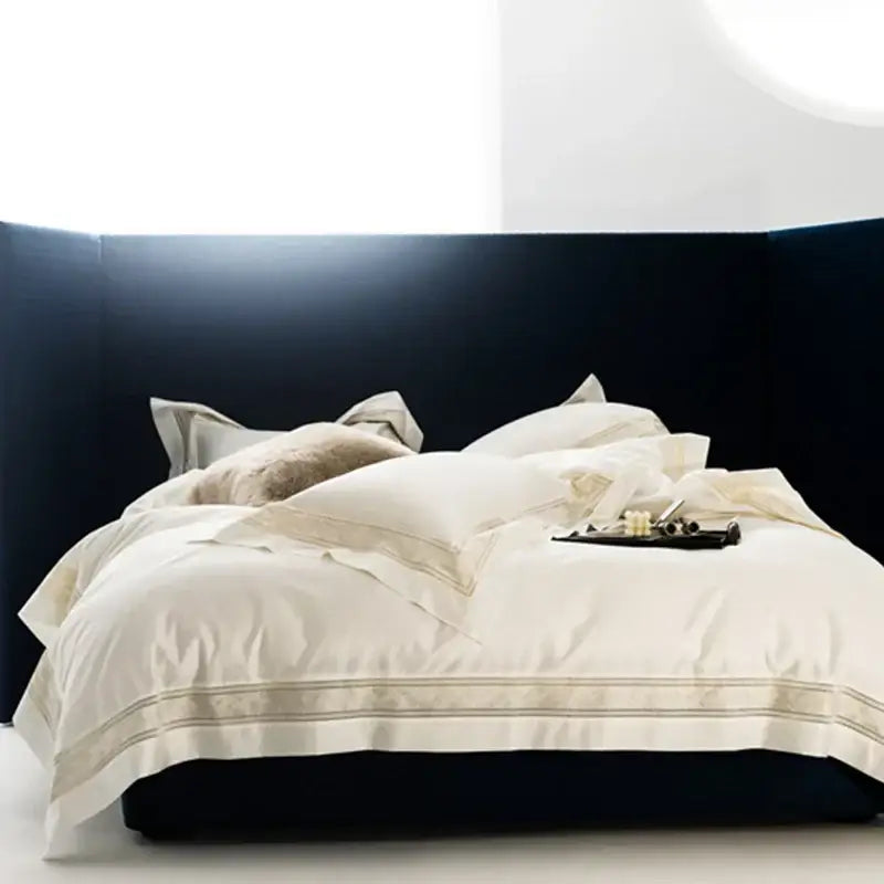 Cream gold wide edge embroidery bedding set in cream satin with gold piping on dark navy bed by decorbites in two sizes