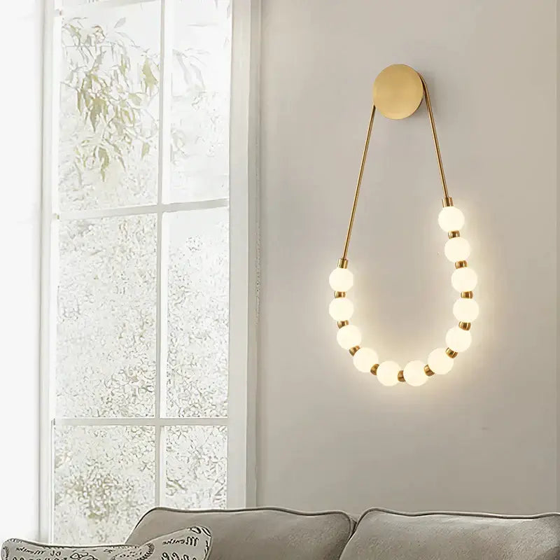 Cream italian style gold globe wall lamp with frosted glass globe bulbs in elegant curved design for bedroom decorbites