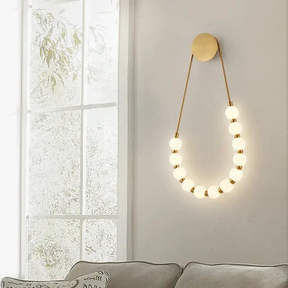 Cream italian style gold globe wall lamp with frosted glass globe bulbs in elegant curved design for bedroom decorbites
