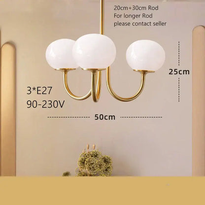 Gold-toned pendant light with three frosted white glass globes for cream pink bedroom decor by decorbites