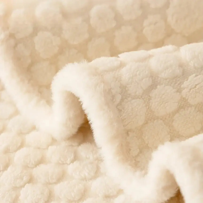 Cream plush loop yarn jacquard knit sofa slipcover with a soft textured surface featuring raised circular patterns