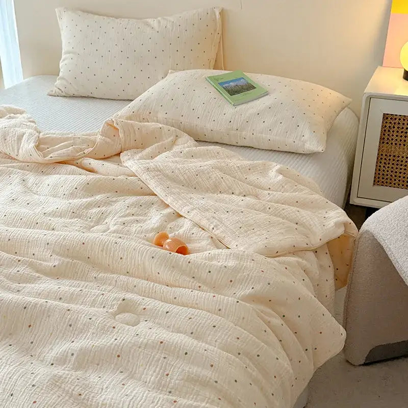 Cream polka dot floral quilt set featuring a cream-colored cotton muslin quilt with subtle polka dots and textured weave