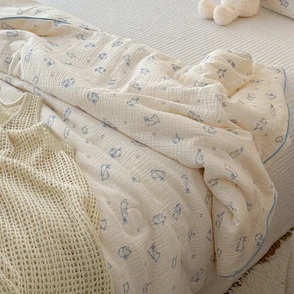 Cream-colored muslin blanket with delicate blue bunny and heart pattern and soft frayed edges in quilt set polka dot floral theme