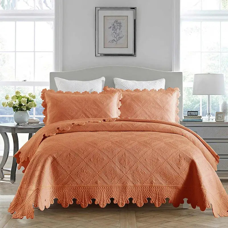 Coral-colored cotton embroidery quilt set with scalloped edges and diamond pattern ideal as a bedroom bedspread