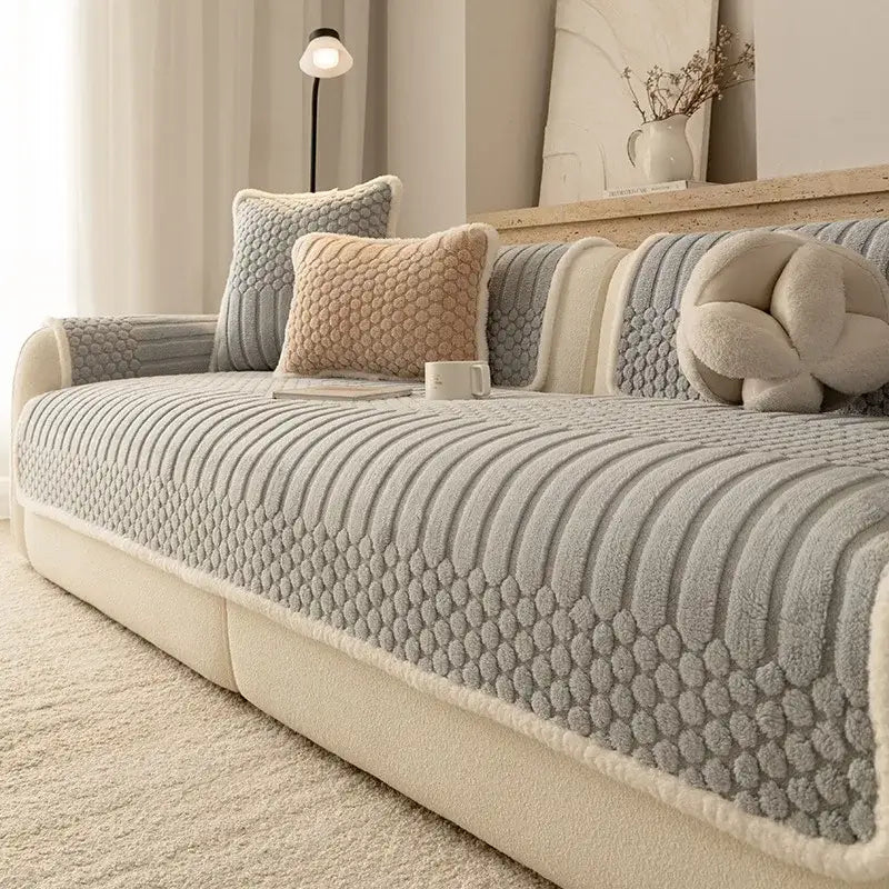 Gray textured sofa cover with plush quilted pattern and cream fleece trim made of jacquard knit fabric for living room use