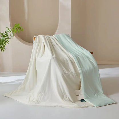 A creamy white and pale mint green ice cream silk quilt with subtle button detailing by decorbites ice cream