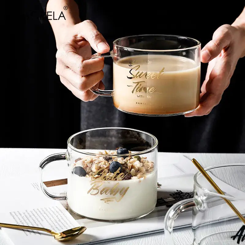 Clear glass mug with gold sweet time inscription and integrated handle held against dark background creative alphabet glass juice cup