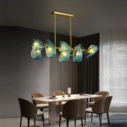 A modern pendant light with five translucent teal decorbites blue glass shades and gold-toned metal frame chandelier