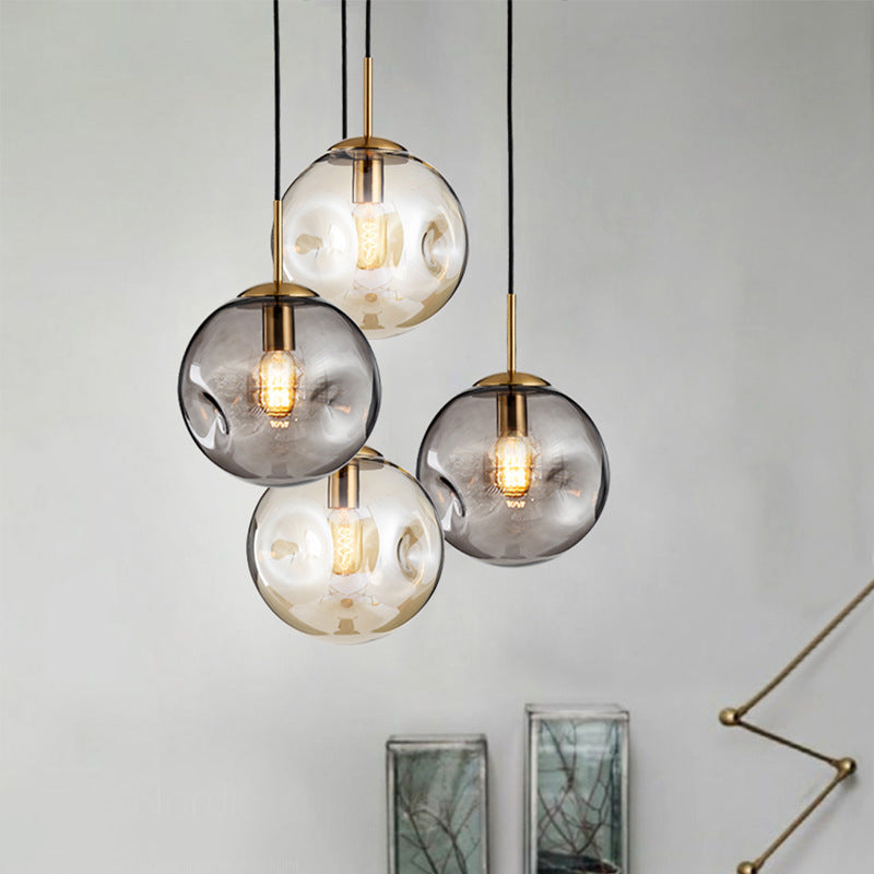 Modern creative glass chandelier with smoky gray globe, gold accents, black cords, and led lamp for restaurant window use