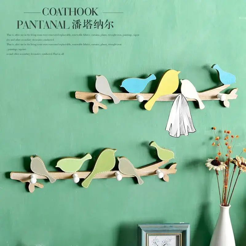 Wooden green and beige birds coat rack with colorful painted bird figures and white spherical knobs for wall decorbites coat rack