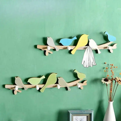 Two decorative wooden birds coat racks with pastel blue green and yellow painted birds for entryway decor