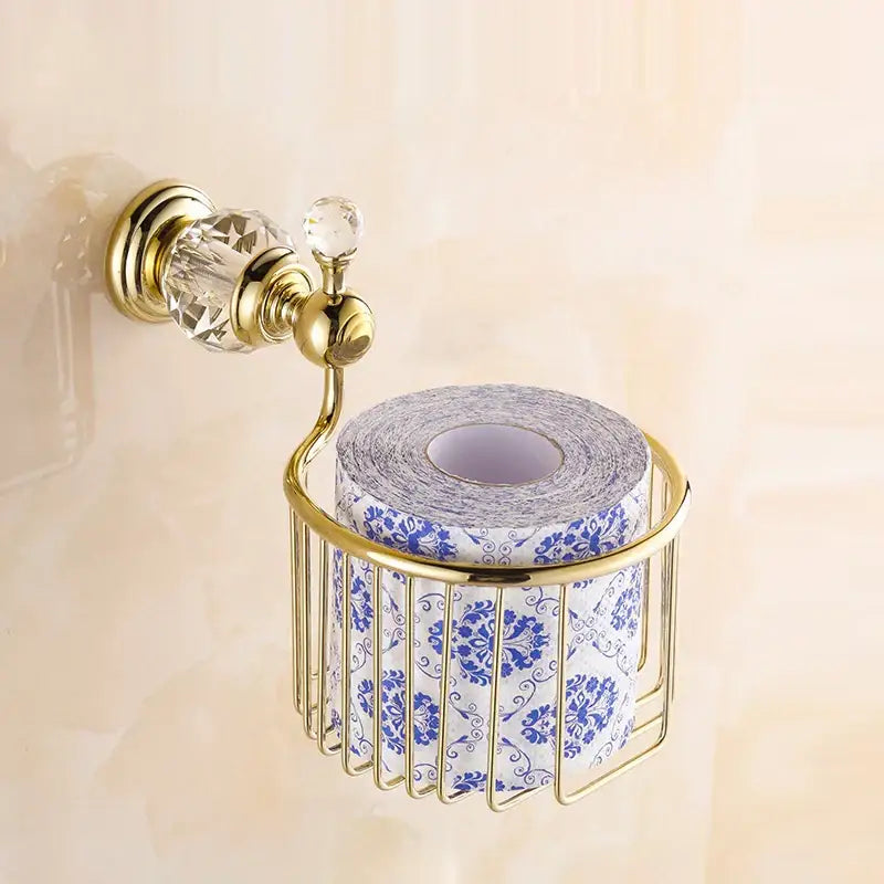 Crystal brass gold toilet paper holder with gold-toned brass and crystal accents holding blue floral toilet paper roll