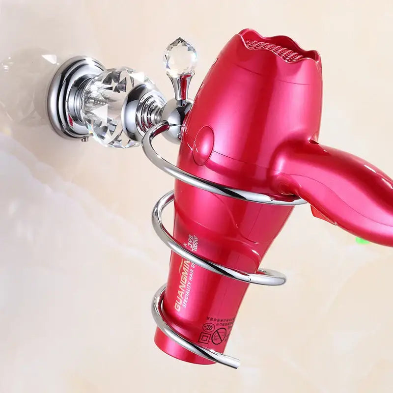 A vibrant red guangmin hair dryer with a glossy finish held in a crystal brass gold spiral holder for brass gold bathroom decorbites