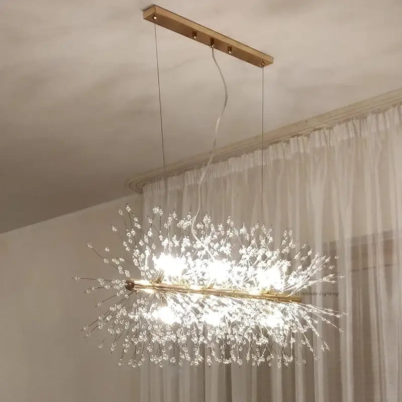 A modern gold-toned decorbites dandelion chandelier pendant lamp with clear crystal strands for dining room use