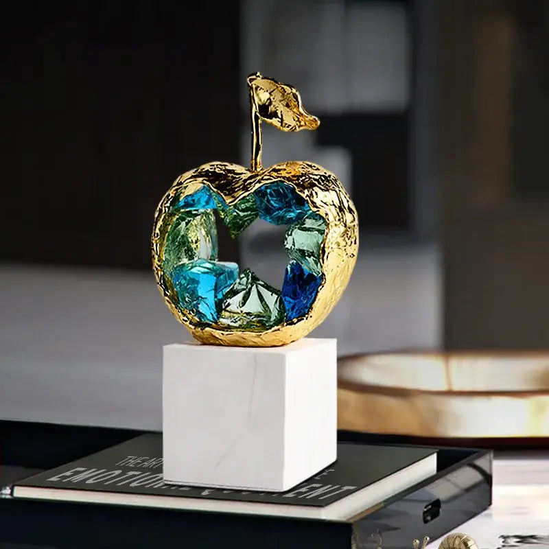 Golden apple decorbites crystal fruit sculpture with textured metal exterior and vibrant blue green glass interior for living room
