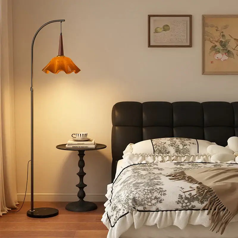 Curved black metal floor lamp with warm amber petal glass shade perfect for living room floor lighting and decor