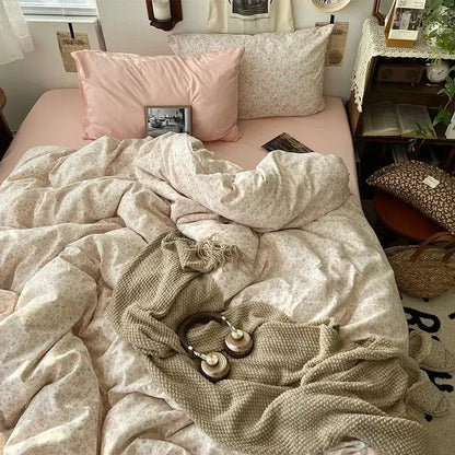 The cute cartoon washed cotton bedding set features cream fabric with pink floral patterns and matching pillows