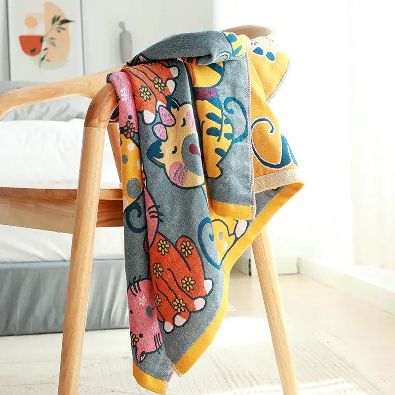 Cute cat bath towel with gray base featuring colorful orange and pink animal characters in a knitted bathroom wrap