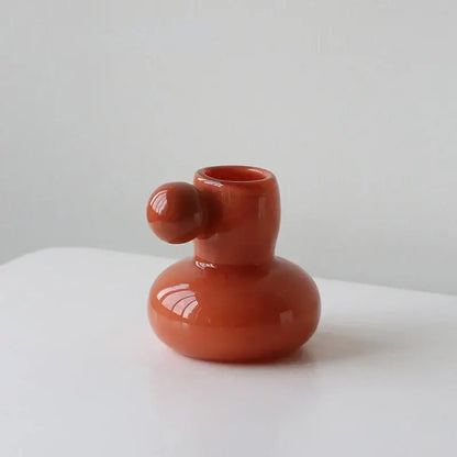 A glossy terracotta ceramic candle holder with a rounded base and small spherical knob for decorbites cute glass ball decor