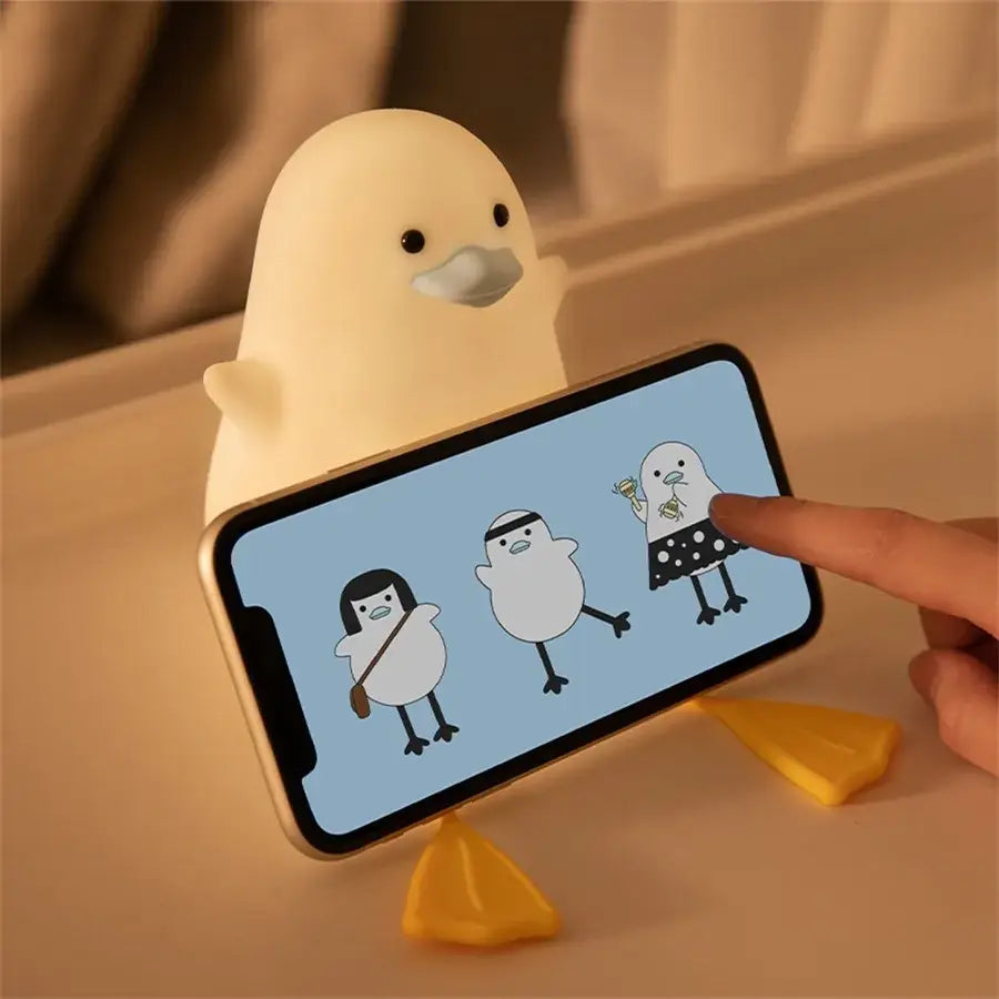 Cream-colored soft silicone duck cartoon phone stand with gentle glow and tiny yellow feet night lamp decorbites night light