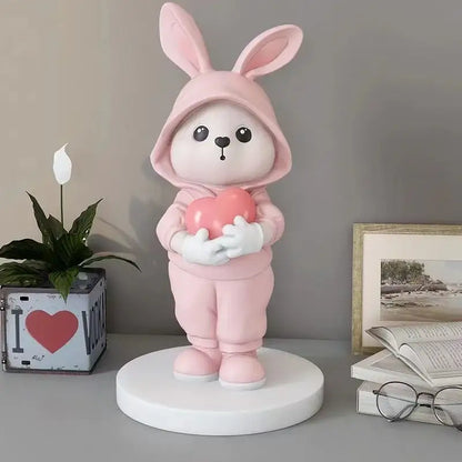 Cute pink rabbit desk figurine wearing a hooded outfit and holding a heart for home decor and rabbit desk use