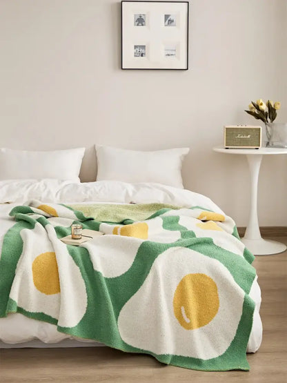 Cozy cream and green knitted throw blanket with playful oversized yellow yolk pattern perfect for decorbites cute poached decor