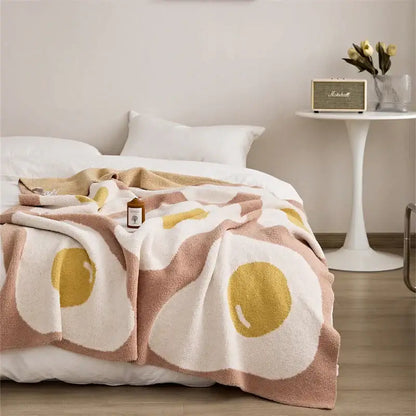 Soft plush poached egg blanket in creamy white and golden yellow on pink knitted throw for bedroom decorbites cute poached decor