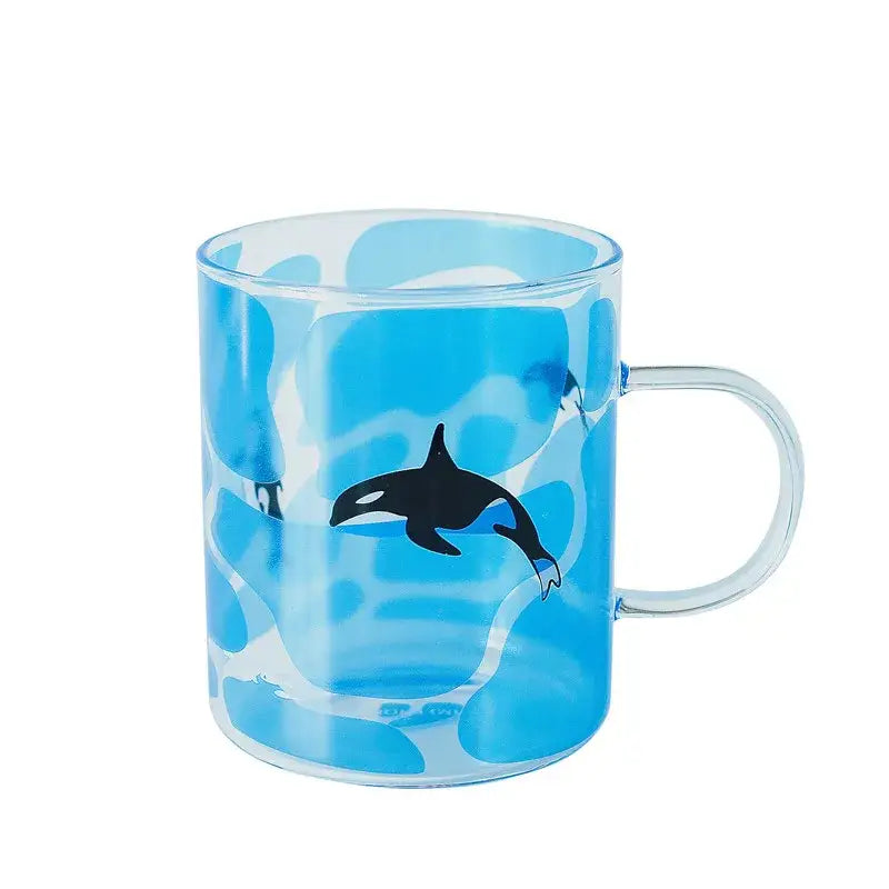 Transparent blue glass coffee mug with black orca illustration and swirling watercolor background heat resistant design