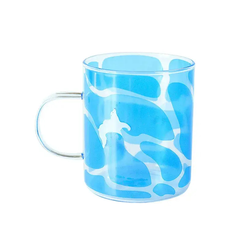 A translucent blue glass coffee mug with white abstract pattern and silver handle heat resistant for tea or coffee