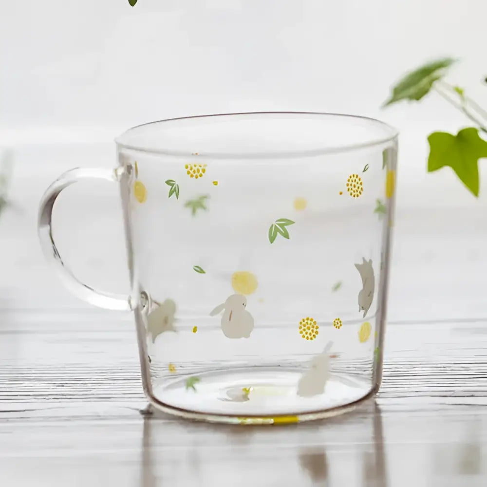 Clear glass coffee mug with delicate gray bunnies green leaves and yellow flowers heat resistant for kitchen use