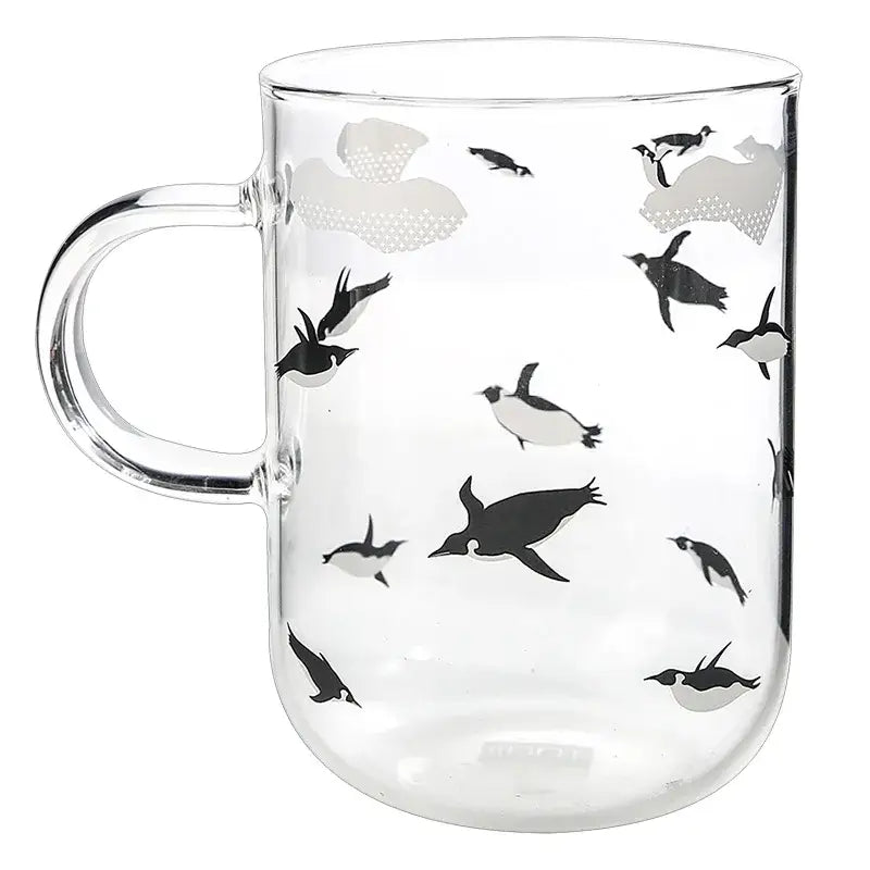 Clear glass coffee mug featuring a playful black and gray penguin pattern heat resistant for tea and coffee use