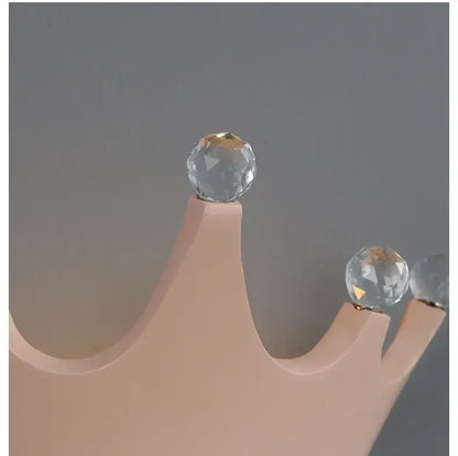 A peach-colored wooden wall sconce crown with faceted clear crystal orbs from decorbites cute resin crystal collection