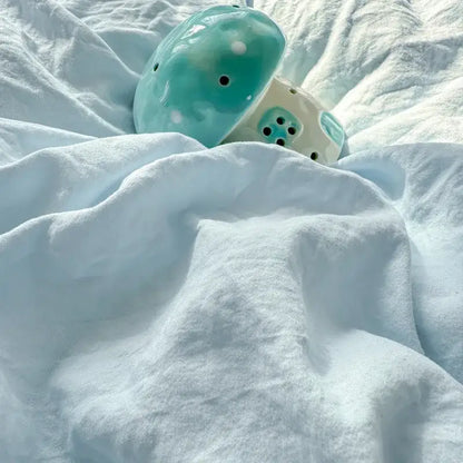 Turquoise ceramic mushroom with white polka dots and black holes complementing cute teddy bear cartoon embroidery bed sets