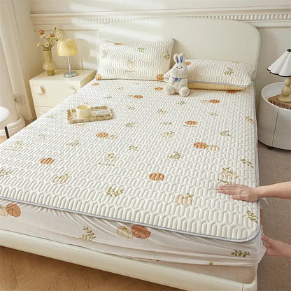 Cream-colored quilted bed pad with subtle pumpkin and leaf pattern complements cute cartoon pattern cooling fitted sheet