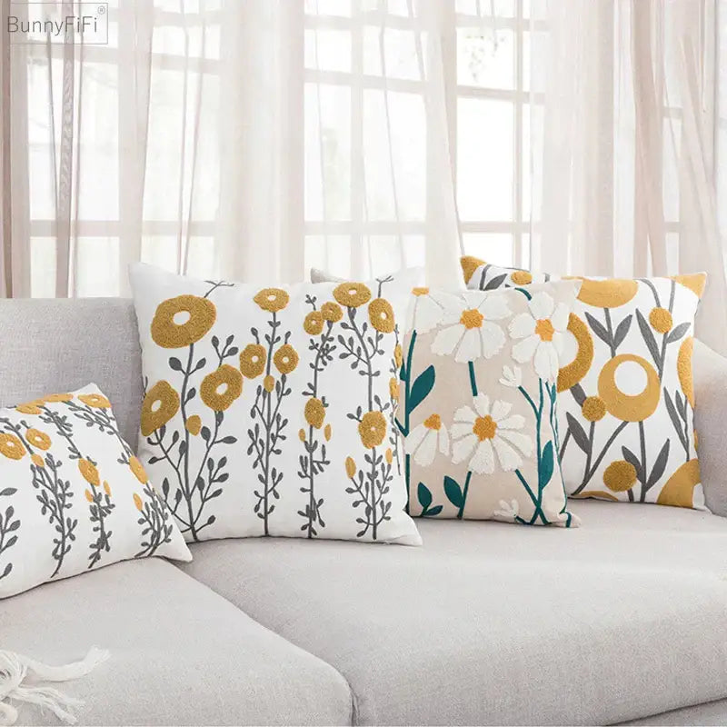 Set of three decorbites daisy home pillow covers with embroidered floral patterns in mustard yellow white and teal on beige