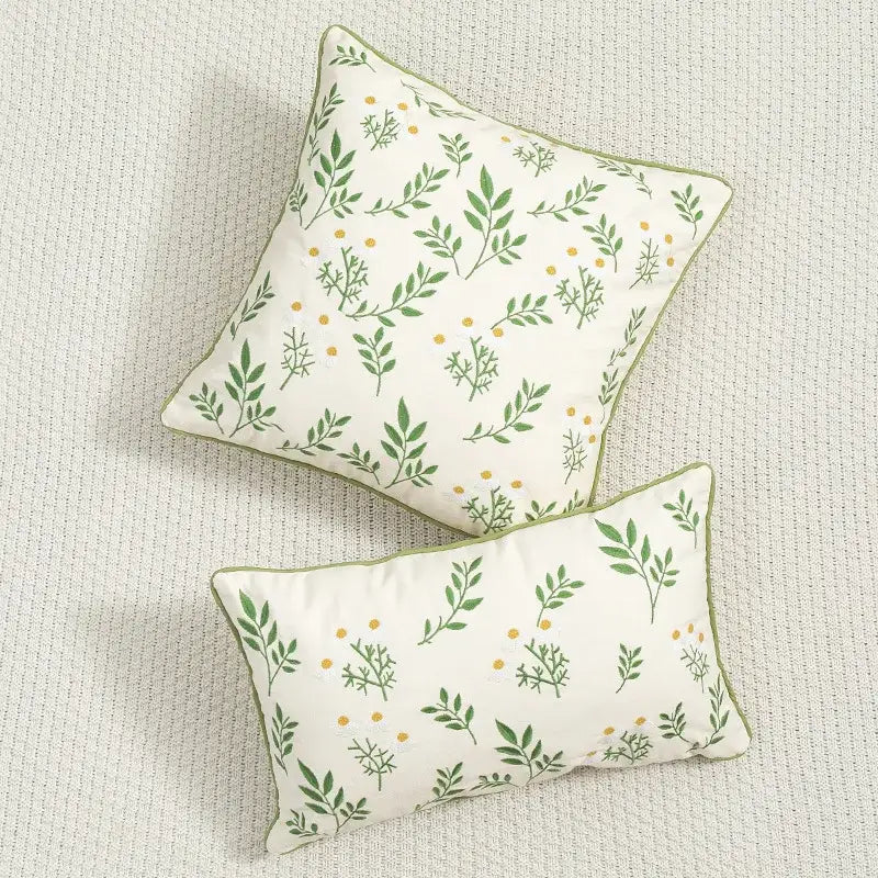 Cream-colored cushion cover with daisy floral embroidery and green leaf patterns by decorbites for living room decor