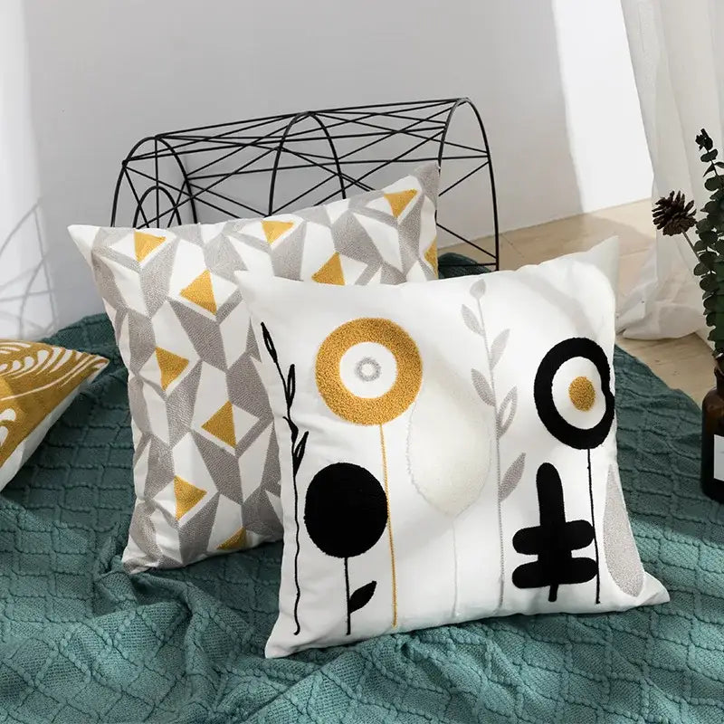 White throw pillow with geometric embroidery featuring black gold and gray daisy floral design for living room decorbites decor